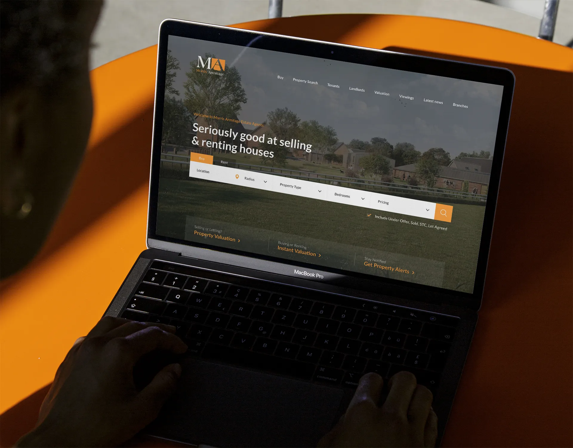 a laptop showing an image of a real estate website